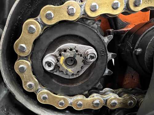 Front sprocket with old chain still attached, showing plate that locks the sprocket in place